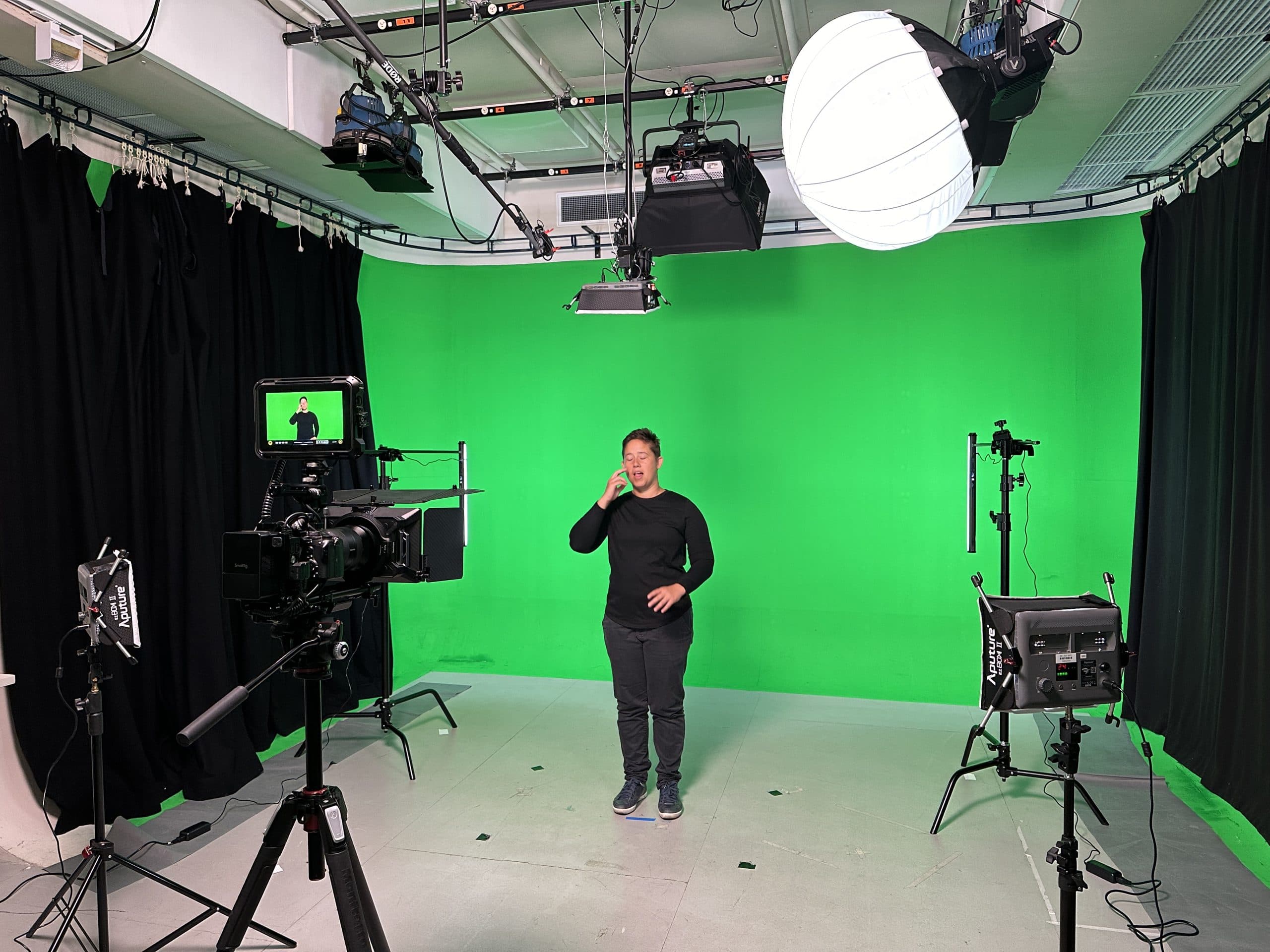 A presenter signs to camera in AC’s production studio.